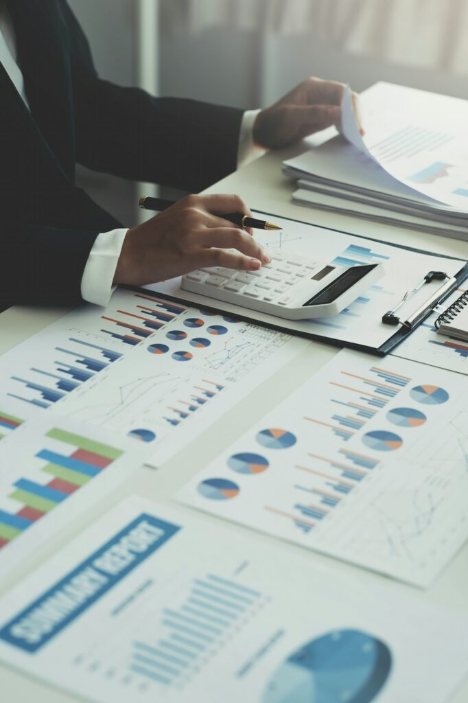 businesswoman working on desk office with using a calculator to calculate the numbers, finance