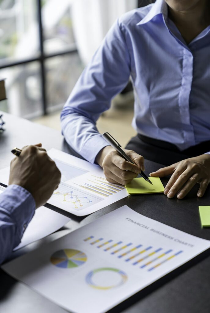 Paperwork and hands on a board room table at a business presentation or seminar. analysis report Che